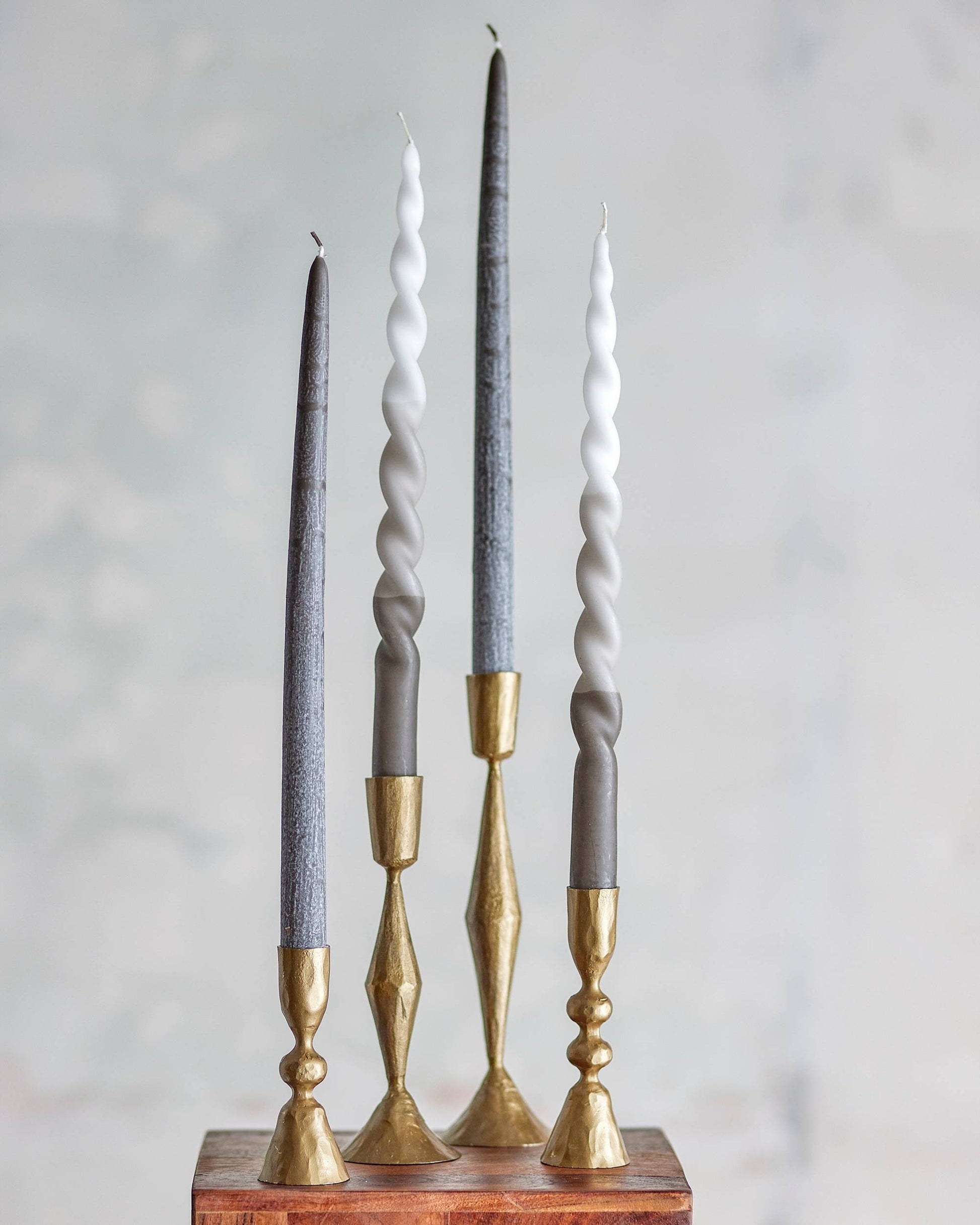 Kerzenset aus 4 Kerzen in den Farben grau weiß. Zwei von vier Kerzen sehen jeweils gleich aus.